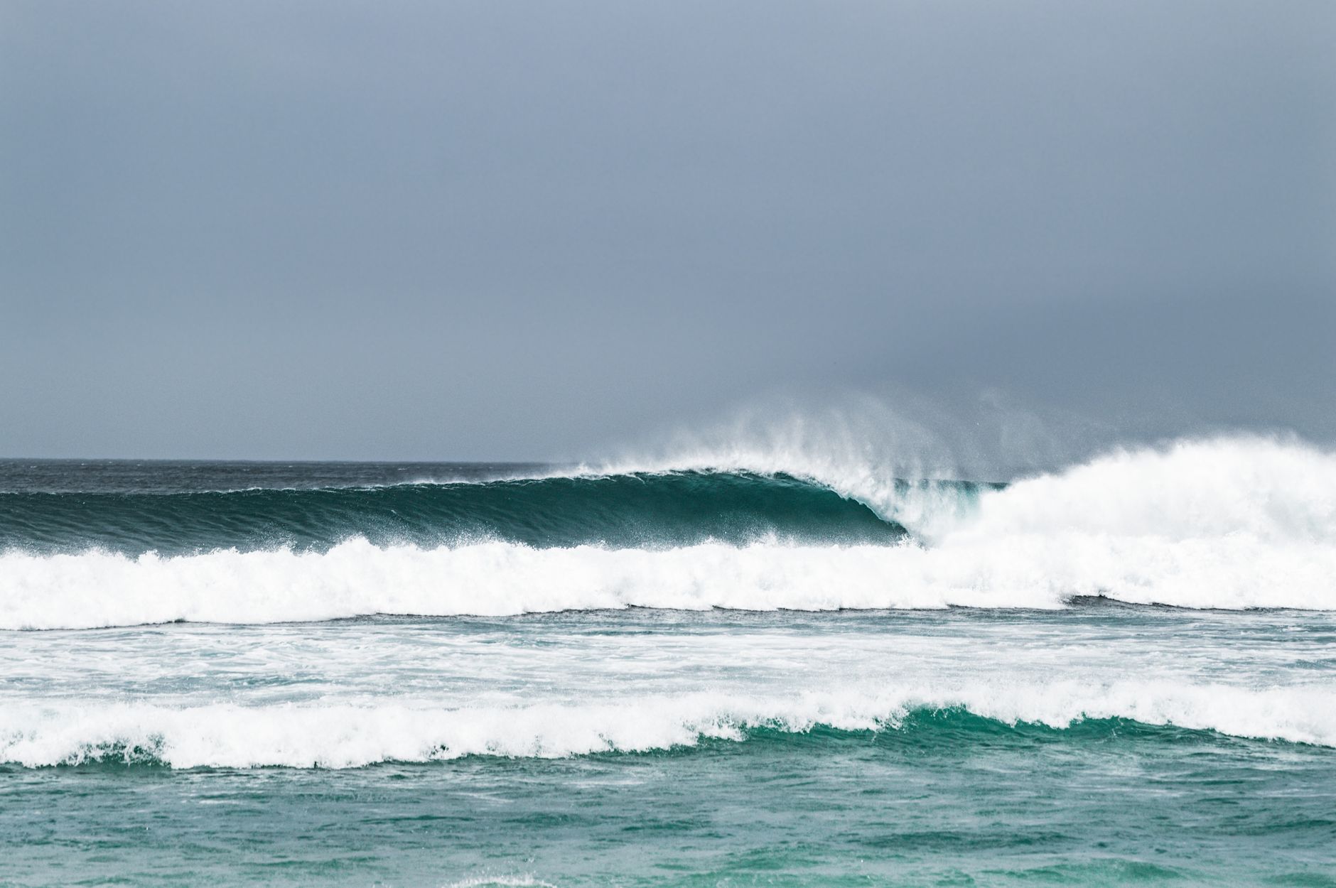 Powerful ocean waves crash on the shoreline, capturing nature's raw beauty and strength.